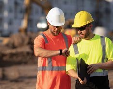 Two construction workers checking the schedule on a jobsite