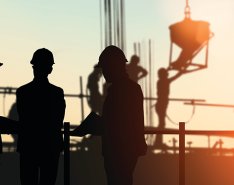 silhouettes of construction workers on site