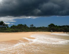 Waves rolling onto beach with storm clouds overhead