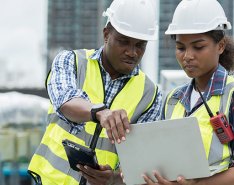 Two construction workers looking at computer