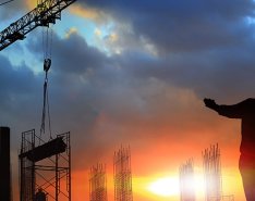 Construction workers standing in field with power equipment