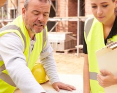 People in construction vests looking at plans together