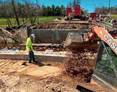 A construction site with heavy machinery and construction workers wearing bright safety colors