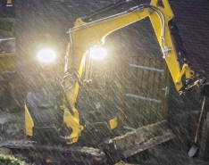 A yellow excavator in the rain