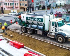 Five men work on a construction site with a large cement truck