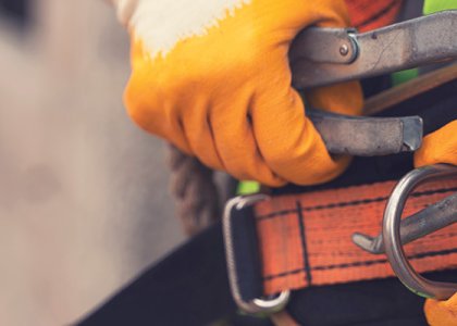 Worker attaching safety harness to show construction worker safety 
