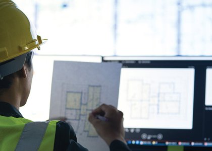 Construction worker in hard hat using technology