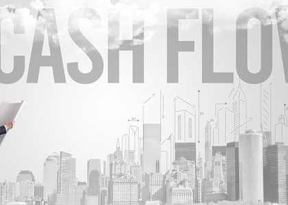 Man in hard hat standing in front of illustration of city with the words "cash flow" over it