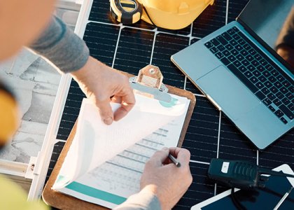 Worker looking at charts and laptop to illustrate subcontractor default insurance 