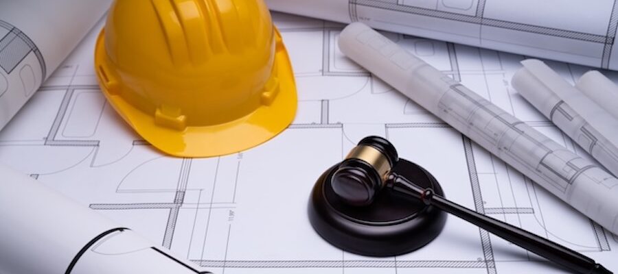 Hardhat and gavel atop blueprints