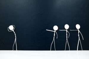 four stick figures pointing fingers at one