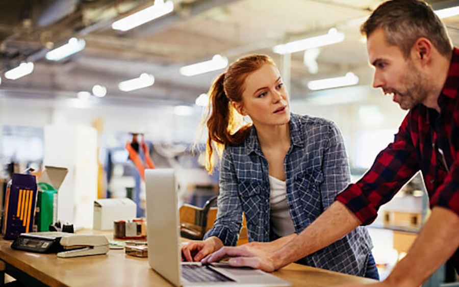coworkers discussing something on computer screen