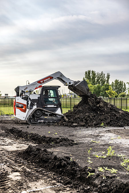 Bobcat T66 compact track loader dumping dirt from bucket