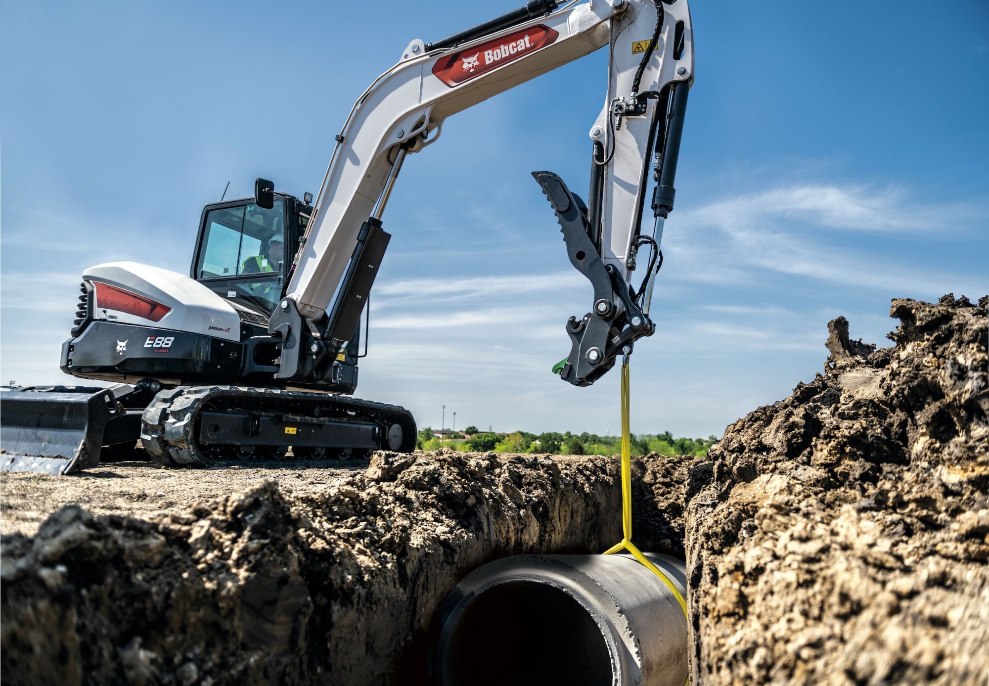 Bobcat excavator lifting material on jobsite