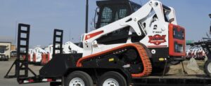 Compact track loader on equipment trailer