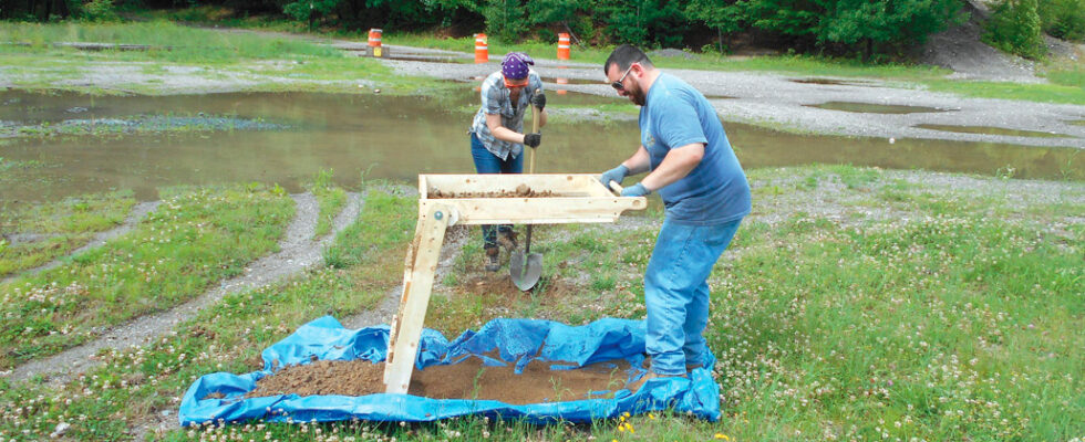 Workers conducting soil testing at construction site