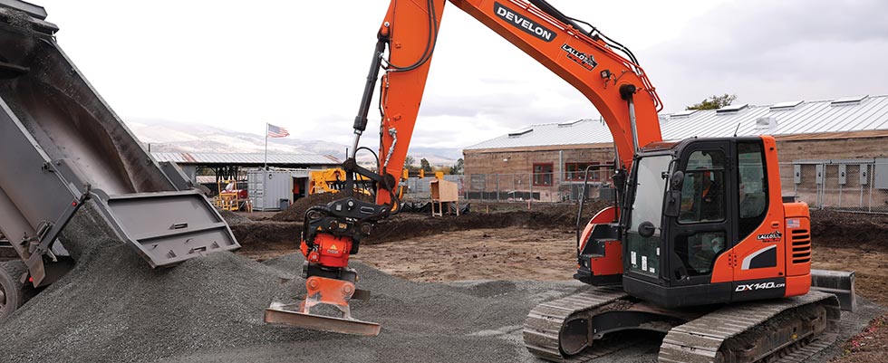Excavator with hydraulic attachment at jobsite