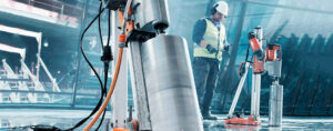 Worker remotely controlling concrete drilling equipment