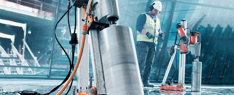 Worker remotely controlling concrete drilling equipment